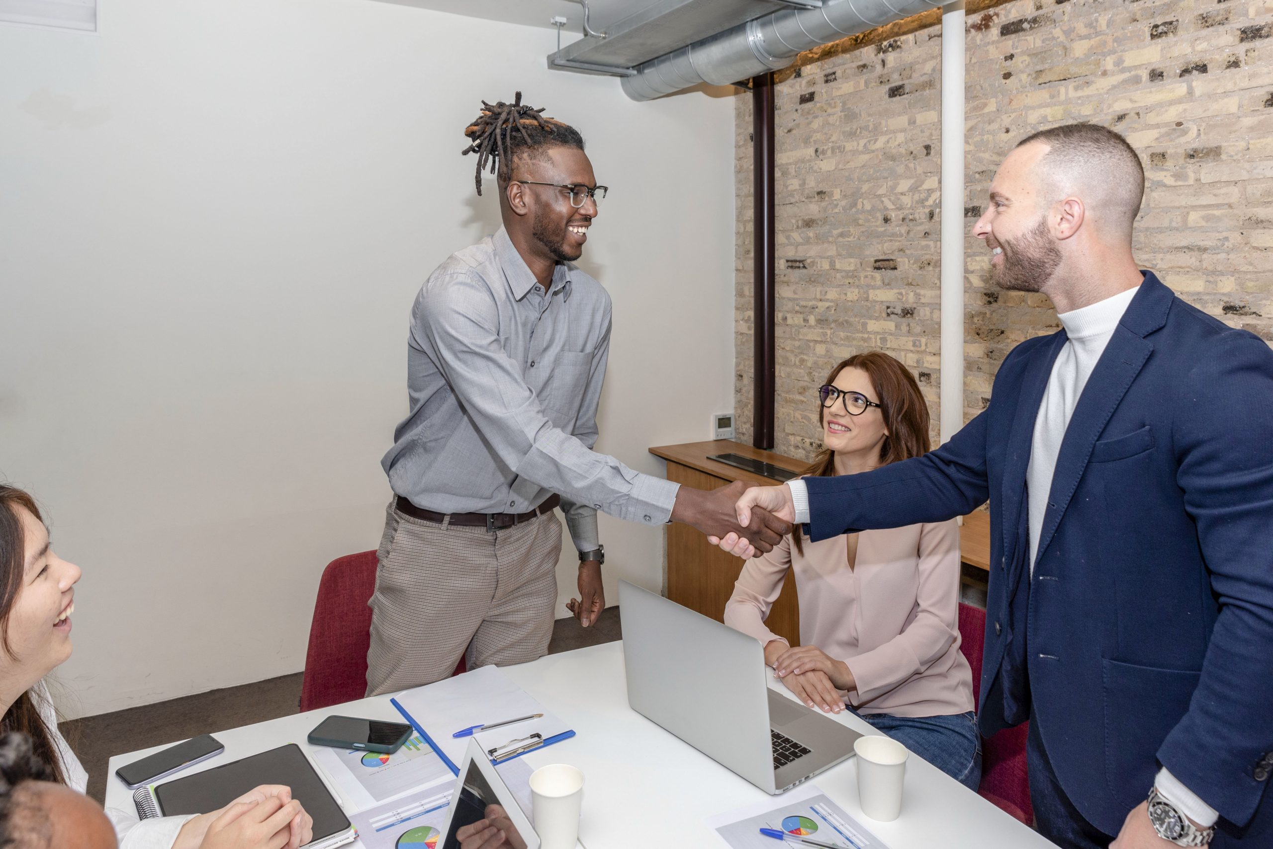 Multi-ethnic businessmen shaking hands and smiling while working in the creative office<br />