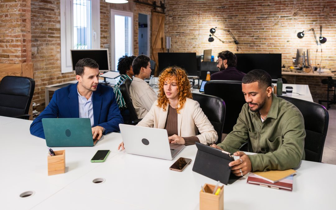 Diverse colleagues using laptops and tablets, working together in a contemporary workspace