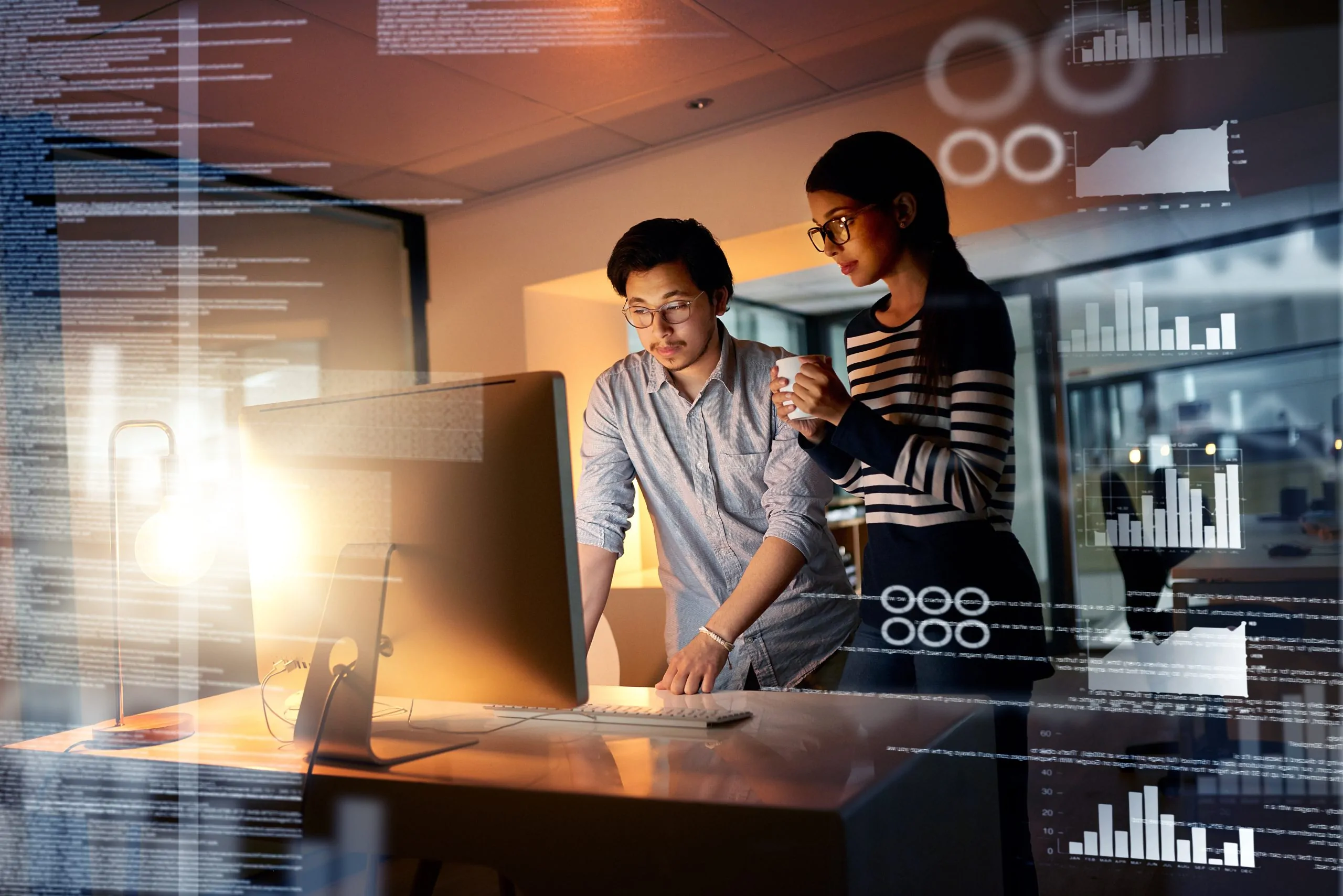 Shot of colleagues connecting to a user interface while working in an office at night<br />